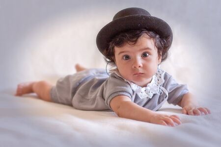 Beautiful little baby in a black hatの写真素材