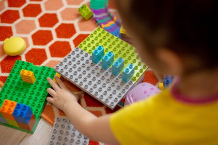 Multi-colored plastic constructor in the hands of the girl. Childrens educational games.の写真素材