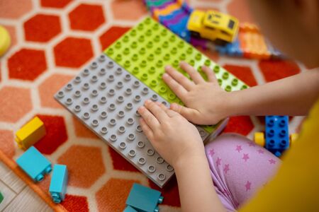 Multi-colored plastic constructor in the hands of the girl. Childrens educational games.の写真素材
