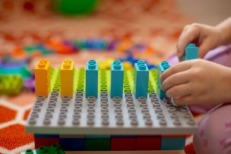 Multi-colored plastic constructor in the hands of the girl. Childrens educational games.の写真素材