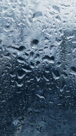Abstract Background with blue drops on glass of window.の写真素材