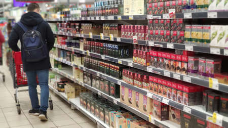 18th of March. Moscow. Russia. A male buyer is walking in a supermarket near the window with tea packetsのeditorial素材
