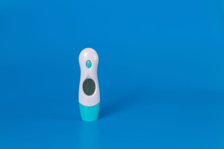 Medical modern electronic thermometer on blue background