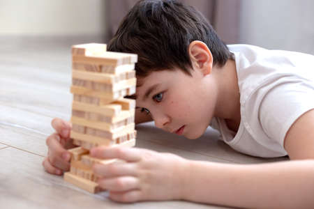 One boy playing a woods game of on the floorの写真素材