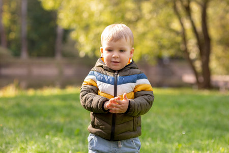 Portrait of a cute smiling little blond boy in a jacket