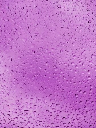 Abstract background with purple drops on the glass window.