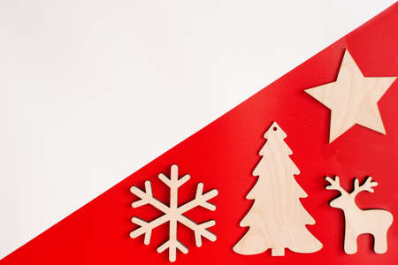 Flat natural unpainted wooden christmas decorations on red and white diagonalの写真素材