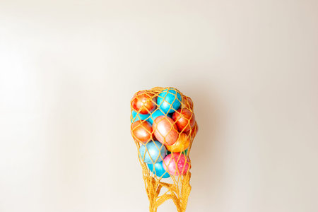 several colorful eggs in an inverted gold knitted bag