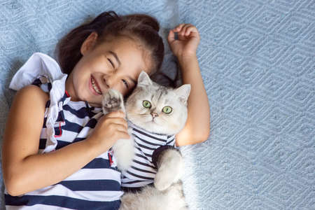 A funny brunette girl lies with catの写真素材