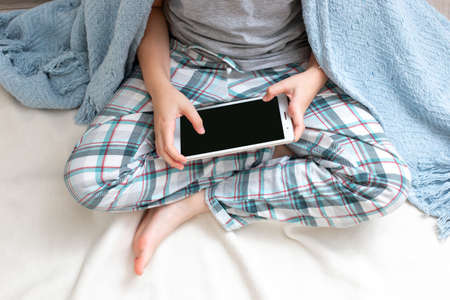 A hands of handsome boy sits holds a digital tabletの写真素材