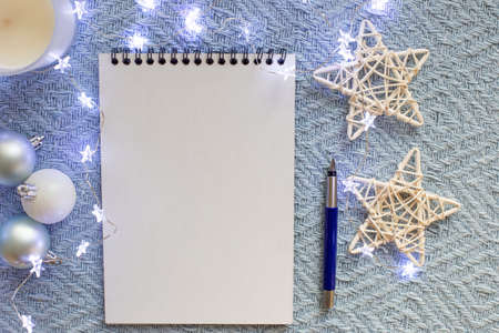 White sheet of notebook, lies on a blue knitted blanketの写真素材