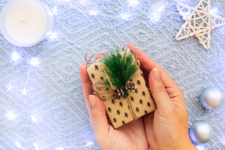 Womans hands hold a small christmas gift