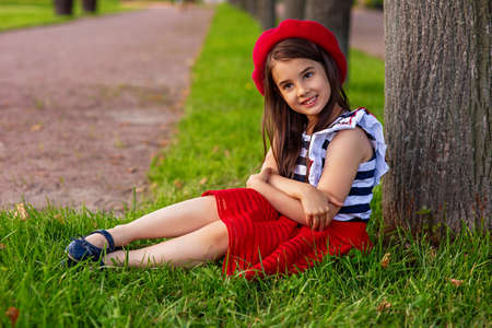 Portrait of a beautiful little brunette girl, in a red beretの写真素材