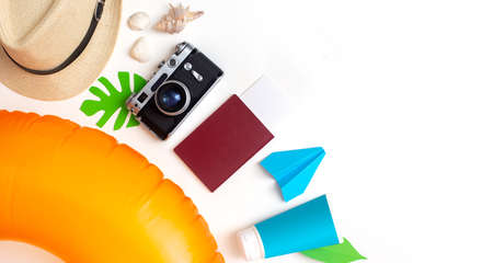 Summer travel set top view: orange swimming circle, passport, camera, straw hat, sun creamの写真素材