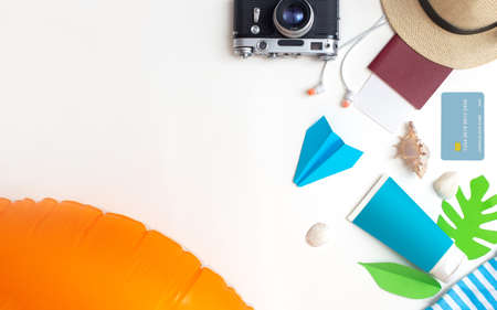 Summer travel set top view: orange swimming circle, passport, camera, straw hat, credit card, sun creamの写真素材