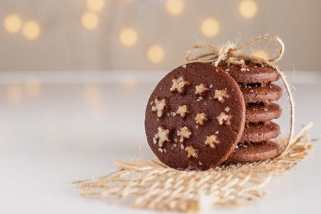 on the table stand is a stack of round chocolate Christmas cookies with sugar stars and salt tied...