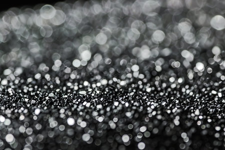 Close-up of silver glitter bokeh with sparkling highlights and abstract textureの素材