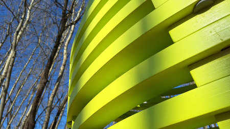 Abstract yellow structure with leafless trees against blue skyの写真素材