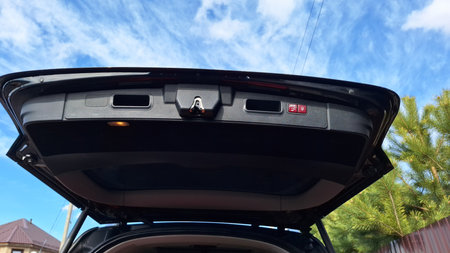 Open trunk lid of modern black suv under blue sky with cloudsの写真素材