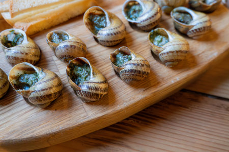 Escargot with garlic butter on wooden platterの写真素材
