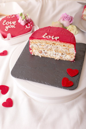 Red valentines cake slice with heart decorations on slate plateの写真素材