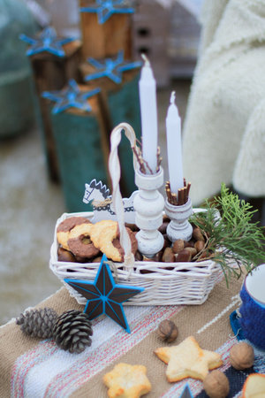 White wicker basket, with cookies and nuts and a sprig of spruce, with white candlesの写真素材