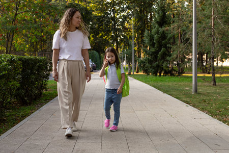 Mother and daughter walking in park: family bonding and nature strollの写真素材