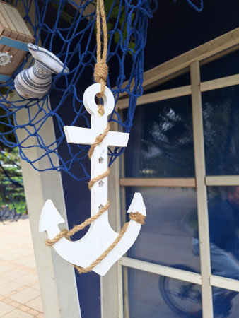 Nautical decor with white anchor on blue fishing net backgroundの写真素材