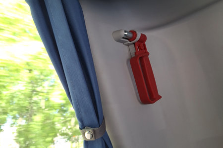 Red emergency hammer and blue curtain inside vehicleの写真素材