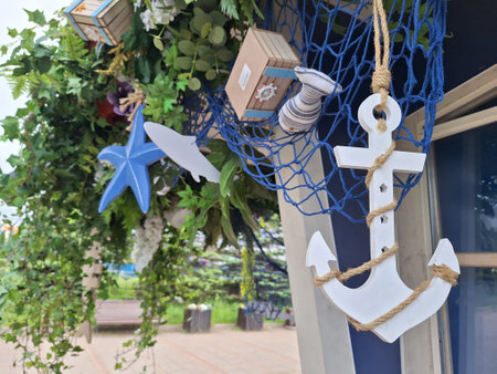 Nautical decor with white anchor and blue starfish amidst green foliageの写真素材