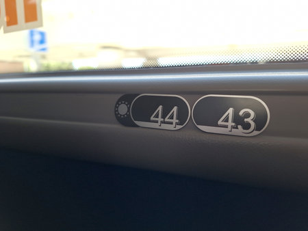 Close-up of train window seat numbers 44 and 43 in daylightの写真素材