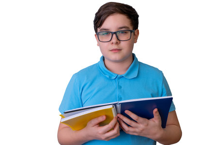 Young caucasian male teen holding notebooks in blue shirt isolated on black backgroundの写真素材