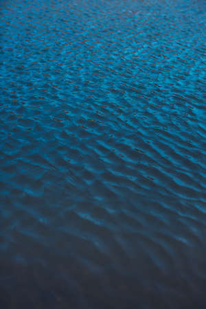 Close-up of water texture, smooth blue waves of water on the shore beach, color landscape photo of waterの写真素材