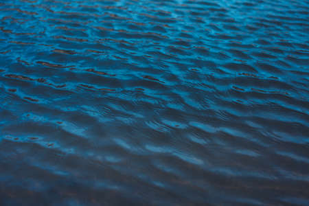 Close-up of water texture, smooth blue waves of water on the shore beach, color landscape photo of waterの写真素材