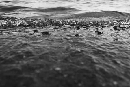 Close-up of water texture, smooth waves of water on the shore, landscape photo of waterの写真素材