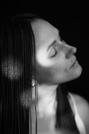 studio black and white portrait of a girl with African zizi braids, emotions on the face of a young...