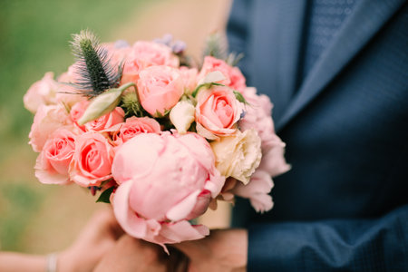 groom holds bouquet, bouquet in grooms handsの写真素材