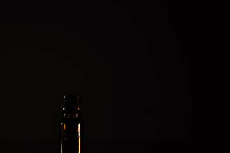 One brown bottles of cosmetics on a natural dark background. Front view.の写真素材