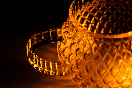 color photo of a glass vessel for a tea ceremony, close-up of the glass texture illuminated with a...