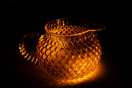 color photo of a glass vessel for a tea ceremony, close-up of the glass texture illuminated with a...