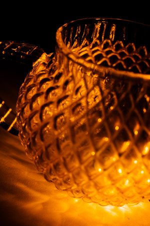 color photo of a glass vessel for a tea ceremony, close-up of the glass texture illuminated with a bright orange light on a dark backgroundの写真素材