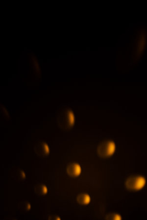 Color photo of a disco ball with orange lighting, a close-up play of light and shadow. Christmas and holiday conceptの写真素材