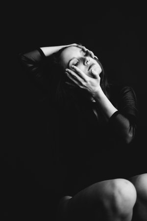 studio black-and-white portrait of a brunette girl, emotions on the face of a young woman, diverse close-up portraits and hand gesturesの写真素材