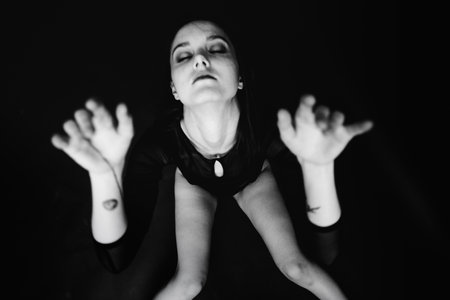studio black-and-white portrait of a brunette girl, emotions on the face of a young woman, diverse close-up portraits and hand gesturesの写真素材