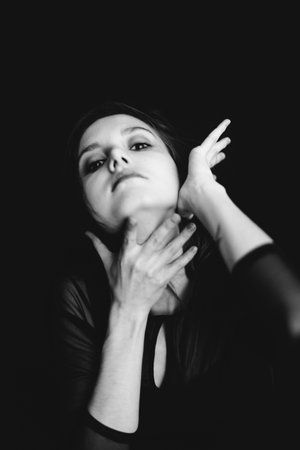studio black-and-white portrait of a brunette girl, emotions on the face of a young woman, diverse close-up portraits and hand gesturesの写真素材