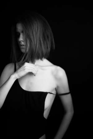 black and white studio photo, a girl with a square in a black bodysuit moves freely and artistically expresses herself in front of the camera, beautiful gestures and facial expressions of the bodyの写真素材