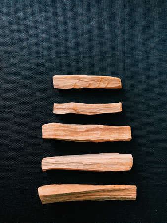 Scattered sticks of Palo Santo tree on a dark background. Top view. Organic holy tree incense from Latin America. Color photo close-up of natural frankincense.の写真素材