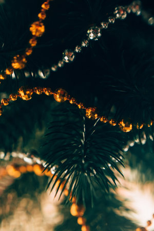 christmas garlands on a green Christmas tree, macro photography, beautiful bokeh