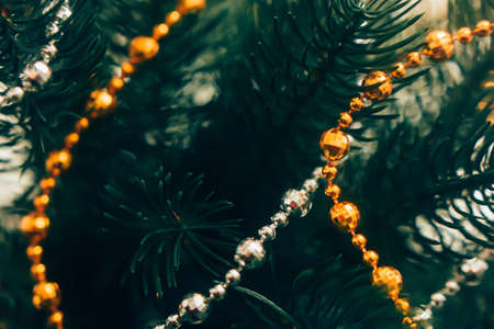 christmas garlands on a green Christmas tree, macro photography, beautiful bokehの写真素材
