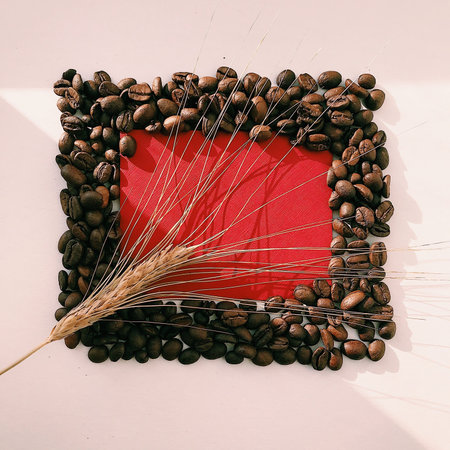 Red envelope and natural coffee beans. Conceptual composition on a light background, top view, space...